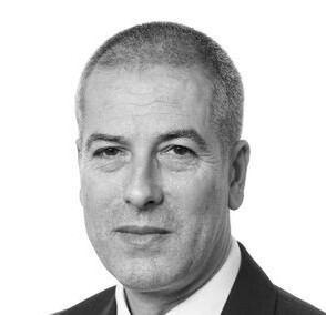 Headshot of Wollens solicitor, Jon Dunkley, in black & white with him smiling at the camera