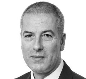Headshot of Wollens solicitor, Jon Dunkley, in black & white with him smiling at the camera