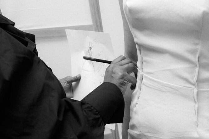 Wedding dress designer in motion during a bespoke wedding dress fitting, calico toile process, behind the scenes in her West London Bridal Atelier