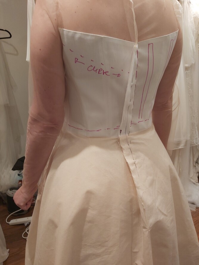 Kate Edmondson working on a bespoke wedding gown during a fitting