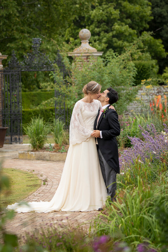 Bride wearing custom made wedding dress at her wedding at Hole Park Gardens
