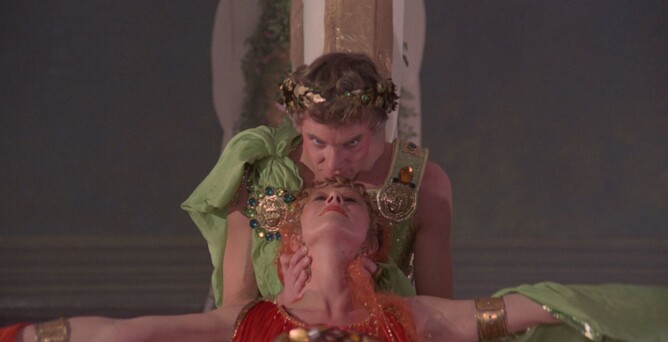 Malcolm McDowell as Emperor Caligula gently kisses Helen Mirren in a striking scene from the 4K restoration of CALIGULA: THE ULTIMATE CUT. The reimagined cult classic showcases expanded performances and unseen footage from the original 1980 film.