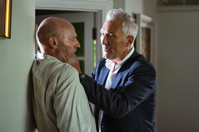 Martin Kemp as Detective John Verney gripping a suspect against a wall in a suspenseful scene from 'DOCTOR PLAGUE.'