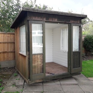 Image Shows the doors open on the summer house and previous improvements made by a previous owner., its all coming out though! Horrible white plastic cladding.