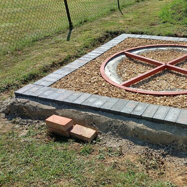 image shows the groundworks complete around the new castor ring. I have set a blue engineering brick edge in place and infilled the ground with gravel to allow drainage.