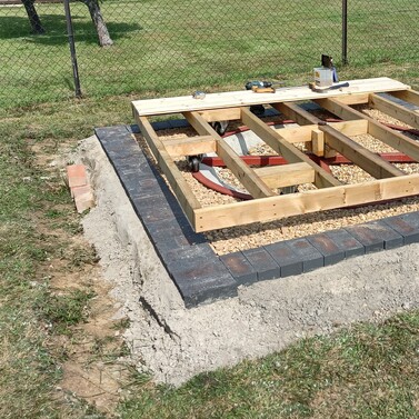 Image shows the timber floor for the summer house being built. 4 x 2 framing with noggins, new castors and then T&G floor boards being fitted.