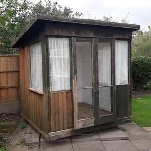 Image shows the old summer house where the owner had started to clean the old exterior wood work which left the walls looking patchy.
