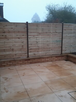 Durapost Brown Posts with slatted panels. - On this install we fitted the slotted Durapost into core drilled holes on a low retainer wall. Set into place using a fast set concrete. The posts had the Durapost cover strip and post cap fitted.
