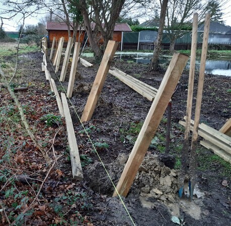 Timber posts and rail fencing being installed.