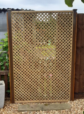 Image shows a a section of Diamond (privacy type) trellis fitted onto brown Durapost (Classic type) posts. Batten has been fitted so that the cover strips and post caps can be installed.
