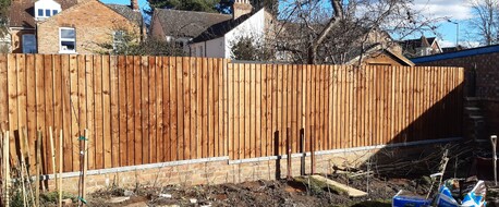 Image shows completed closeboard fence from the front (neighbours) view.  From this side you cannot see the frame work of the fence (posts and rails) just the feather edge boards. The fence components are all pre treated with Brown Tanatone wood treatment.