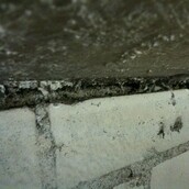 Asbestos spray coating within ceiling gap
