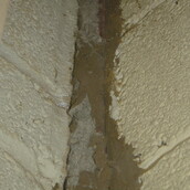 Asbestos sprayed coating to a wall